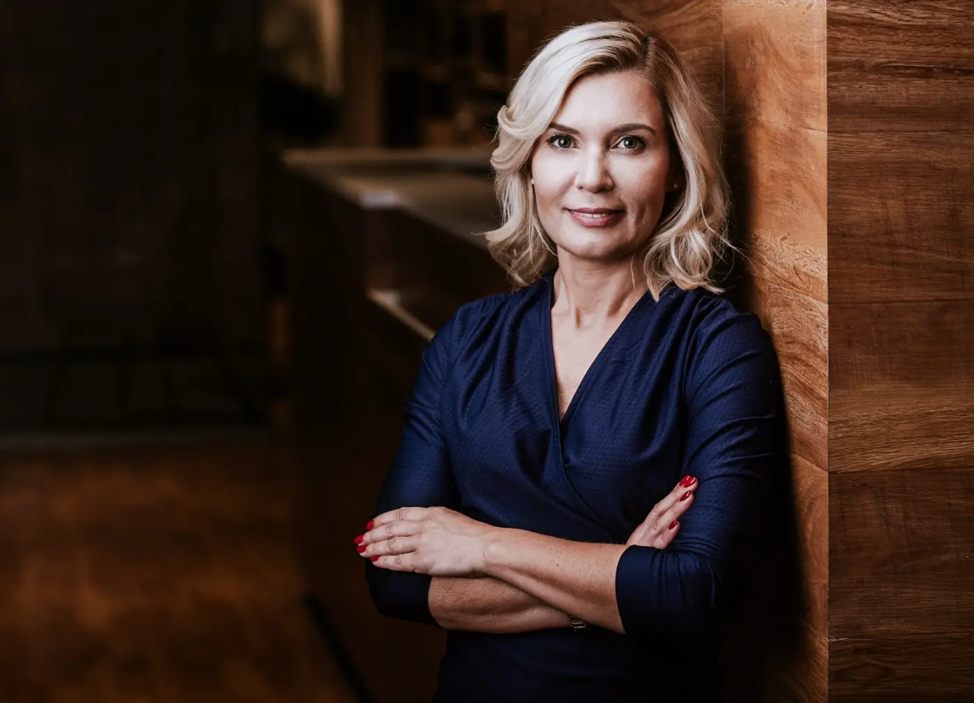 Ewa Pędzich-Ościłowska w granatowej sukience w eleganckim wnętrzu